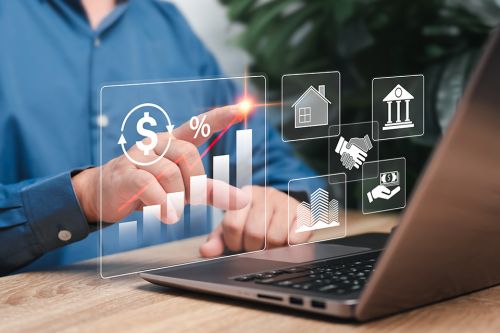 Foto: Laptop mit Symbolen zu Immobilien davor